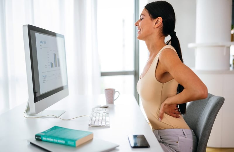 How Pilates Can Help Improve Your Posture - woman at desk stretching