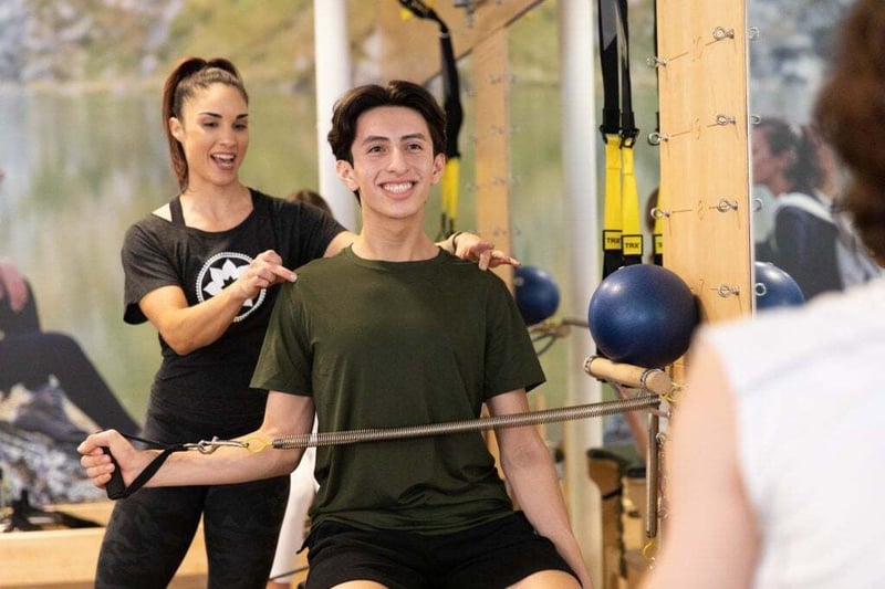 5 Pilates Exercises to Kickstart Your Day - man doing Pilates in studio