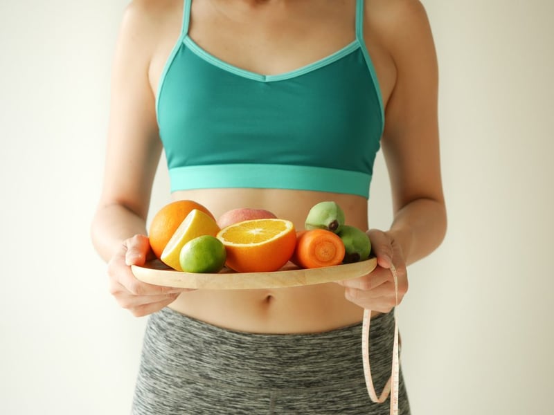 5 Ways to Add More Soluble Fibre to Your Diet - woman holding tray of vegetables and fruit